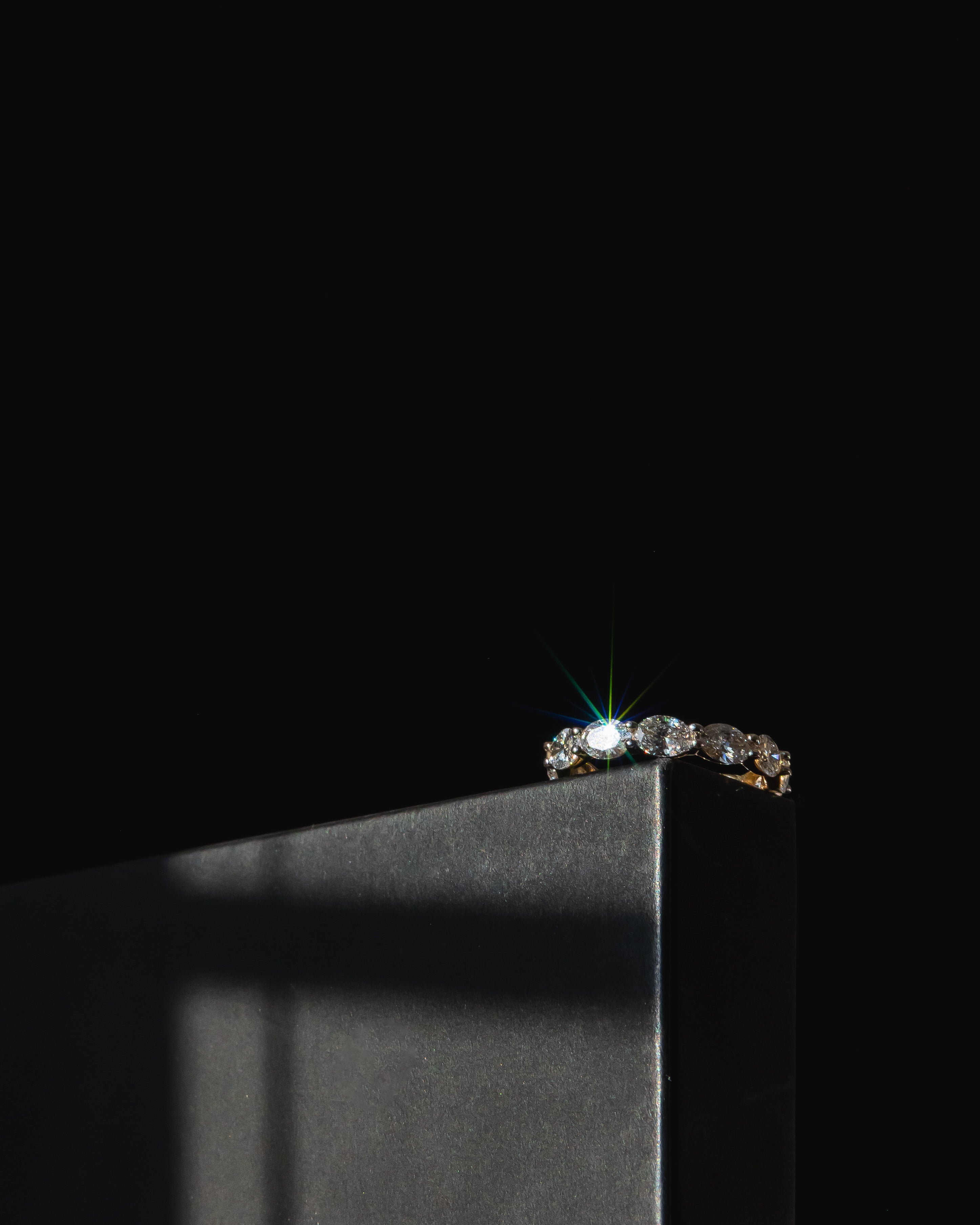 Diamond Wedding band with oval stones with sun glaring as it sparkles